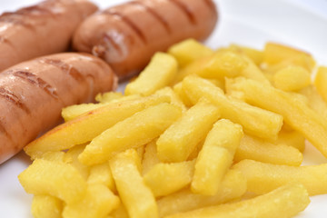 Street food. A dish of sausages and fried potatoes.