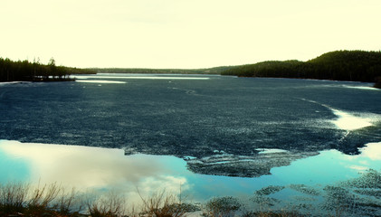 Forest lake in Lapland and the sun's rays in spring