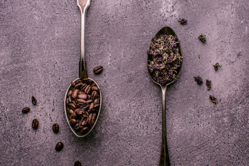 Coffee Beans and Tea in Rustic Spoons over Dark Stone Background