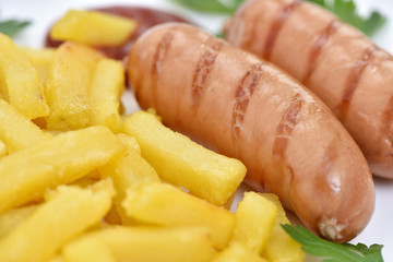Street food. A dish of sausages and fried potatoes.