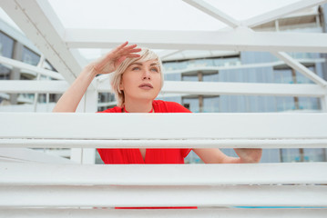 portrait of surprised emotional pretty beautiful blonde woman in red coral dress