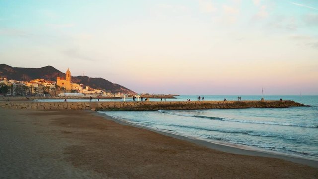 Sitges, Catalonia / Spain: Skyline of the old town with the church seen from the beach at sunset