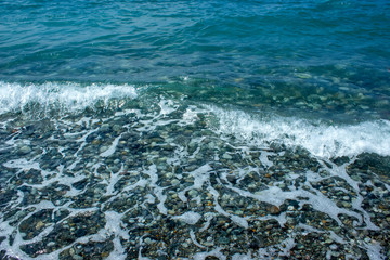 Fototapeta na wymiar Sea stones and waves on the beach. Summer background.