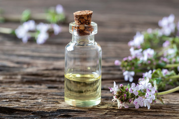 Obraz na płótnie Canvas A bottle of thyme essential oil with fresh thyme