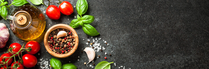 Fresh tomatoes, spices and basil leaves on black background