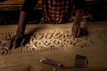 african man doing his work makes a carver door