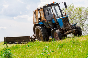 Tractor with a mechanical mower mowing grass