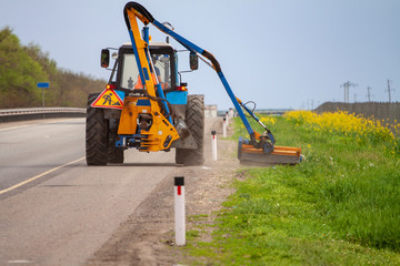 Tractor with a mechanical mower mowing grass