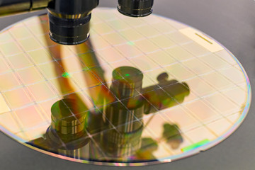 Silicon wafer on machine process examining in microscope.
