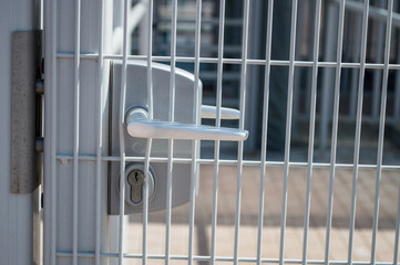 Metal lock on prison metal gate closeup. Metal driveway security entrance gates, locked doors.