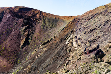 Timanfaya National Park, mountains of fire at Lanzarote, Canary Islands, Spain. Unique panoramic view of spectacular corrosioned lava ground layers structure of a huge volcano cone.