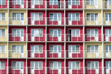 An apartment building red and yellow wall texture with balcony. Architecture background of building walls.