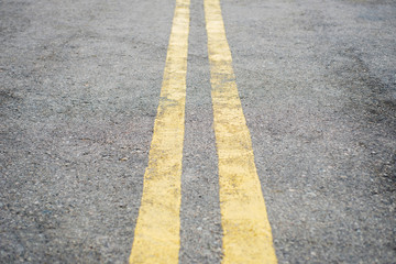 Fototapeta premium Yellow double solid line. Road markings on asphalt on the street. Highway surface with double yellow lines