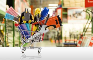 Construction tools in shopping cart isolated on white