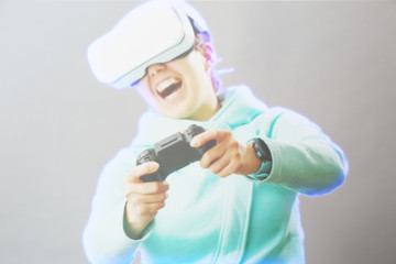 Woman with virtual reality headset is playing game. Image with hologram effect.