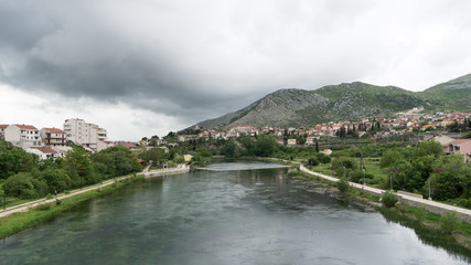 Fototapeta na wymiar Picturesque landscape with town on river bank. Bosnia and Herzegovina, Republika Srpska. View of Trebisnjica river and Trebinje town