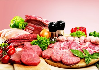 Fresh raw meat background with vegetables on wooden desk isolated on white background