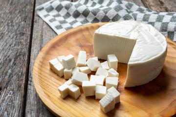 Fresh and tasty mexican panela cheese on wood background