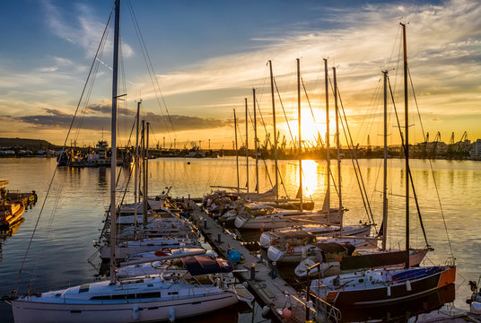 Yachts and boats at stunning sunset in the harbor. Black sea, Varna, Bulgaria.