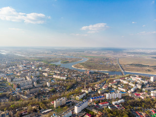 Panorama of a small town, river, forest, fields, road, bridge and sky. The photo was taken by a quadcopter, drone. Summer and spring. Skyview. Top view. Travel and tourism. Created by DGJ drone.