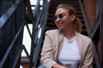 Portrait of happy sucessful woman on steel stairs at her own flat.