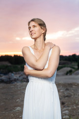 Fototapeta na wymiar woman in white dress on the background of blue sky