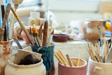 Pile of paintbrushes staying with special wooden and metal tools