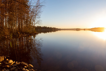 Beautiful and calm scenery in Finland during late night evening during summer. Lake reflection at the shore.