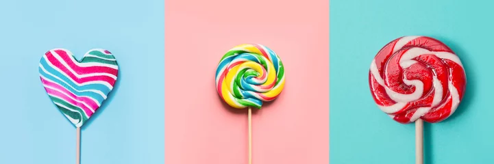 Fotobehang Three colorful lollipops candy as heart and swirl on blue and pink. Funny concept. Top view. Collage. © svetlana_cherruty