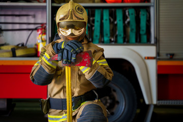 Photo of man fireman in helmet and mask on background of fire truck