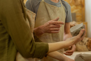 Experienced pottery master in dirty apron sharing his knowledge