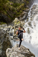 Obraz premium Muay thai fighter training by the waterfall
