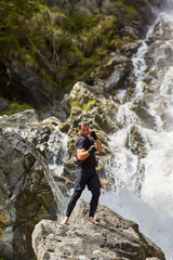 Naklejka premium Muay thai fighter training by the waterfall