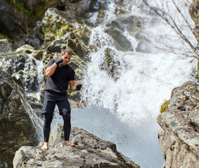 Muay thai fighter training by the waterfall