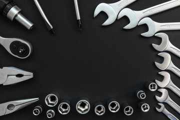 Flat Lay Composition With Different Construction Tools on Black Background. Top View of Checklist and Working Tools, Wrench, Screwdriver, Plier.