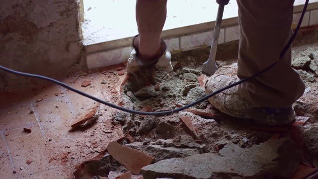 Demolition of old floor tiles with jackhammer