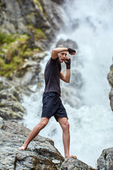 Muay thai fighter training by the waterfall