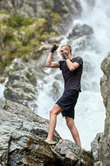 Muay thai fighter training by the waterfall