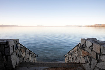 A stairway leading into Lake Tahoe at sunset.
