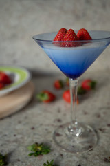 cup with yogurt and three strawberries