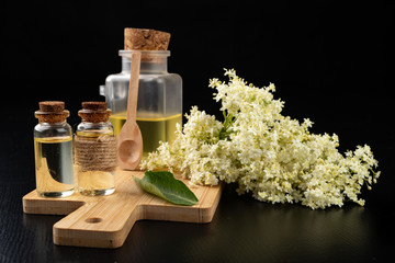 Beautiful flowers of elderberry and medicinal juice in a bottle. Natural home remedies for colds.