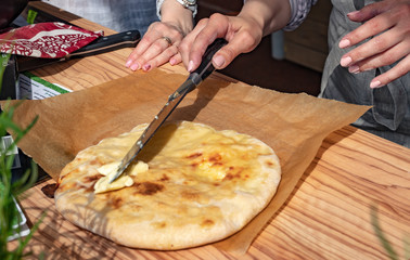 Woman's hands is making georgian khachapuri imeruli. Georgian traditional food, hot khachapuri.Georgian cuisine.