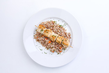 chicken kebab with buckwheat on the white plate