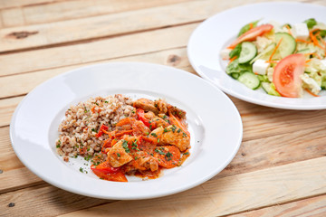 meat with buckwheat and salad on the wooden background