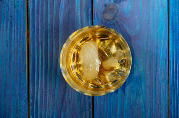 A glass of strong alcohol with ice in a transparent glass