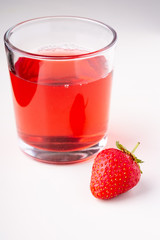 One strawberry with compote drink in glass isolated on white background