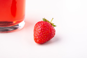 One strawberry with compote drink in glass isolated on white background