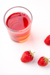 Strawberries with compote drink in glass isolated on white background