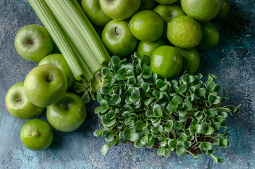 Top view green apples, celery, limes and milk thistle microgreen on a concrete background. Detox program, diet plan, weight loss.