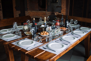 Glasses, forks, knives, plates on a table in restaurant served for dinner.